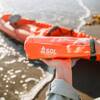 taking items out of kit, kayak in water in background