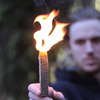man holding lit Behemoth Stormproof Sweetfire