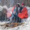 in use in snow with 2 people around fire